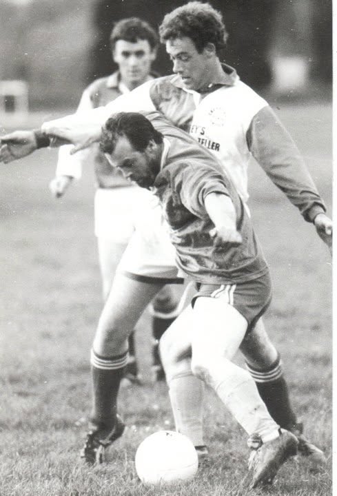 Two players shielding the ball in a midfield tussle