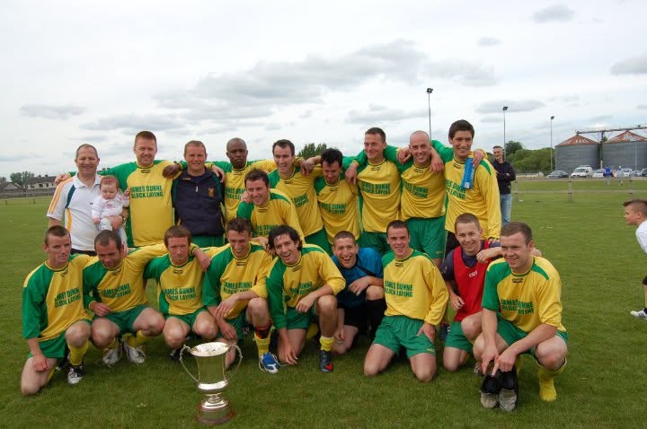 Crettyard United squad celebrating with the cup in James Dunne Block Laying kit