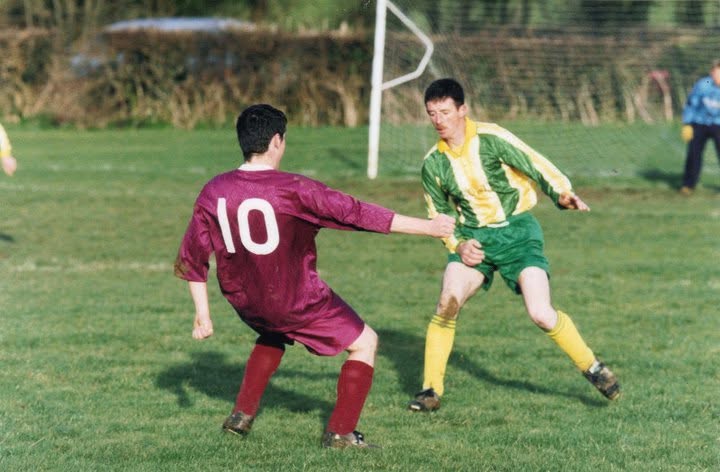 Crettyard United player in green and gold taking on a defender
