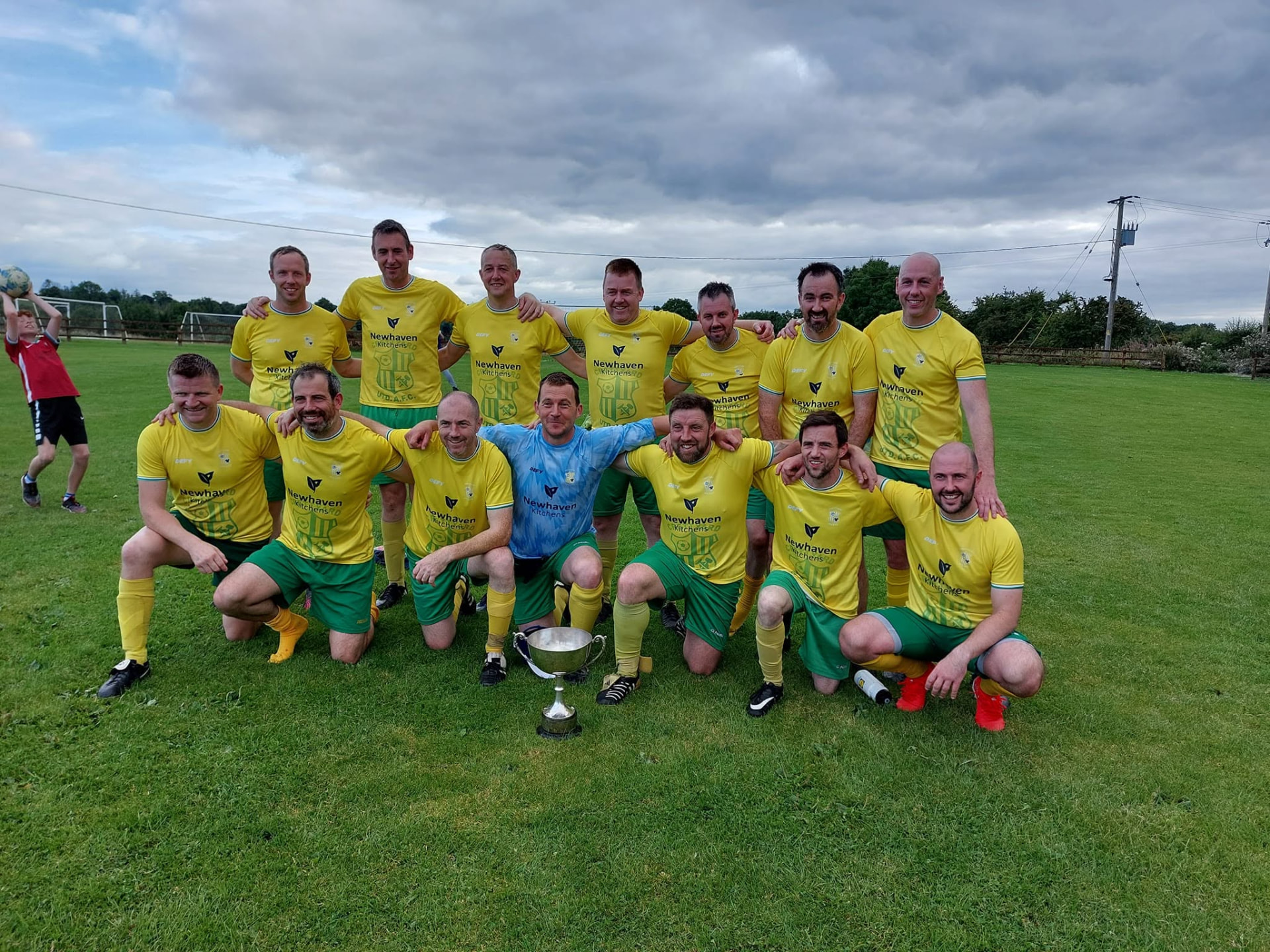 Crettyard United squad celebrating with the cup in Newhaven Kitchens kit