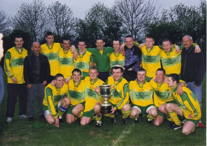 Crettyard United squad celebrating with a cup in The Whiskey Shop kit