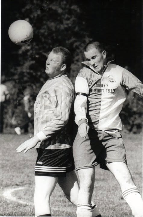 Two players challenging in the air for a high ball