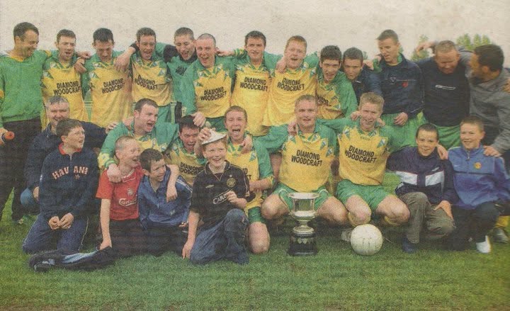 Crettyard United squad and supporters celebrating with the cup in Diamond Woodcraft kit