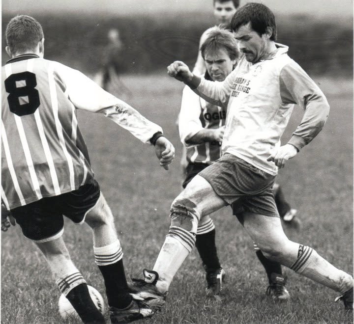 Player firing a shot past a striped defender
