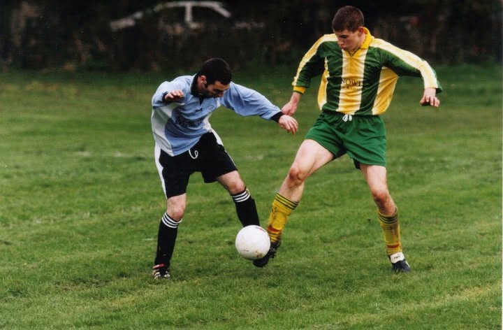Crettyard United player shielding the ball from a sky blue opponent