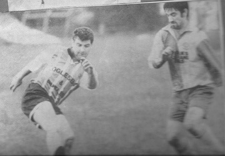 Crettyard United player driving forward past a defender, black and white photo